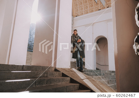 Caucasian man in coat standing on stairs Caucasian man in coat standing on stairs 60262467