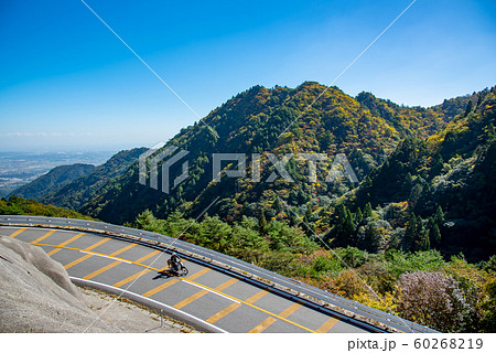 三重県 紅葉の御在所 鈴鹿スカイラインを通り過ぎるオートバイの写真素材