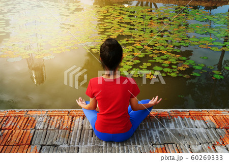 Girl try to tree pose yoga. 60269333