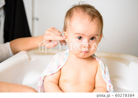 Adorable baby girl taking a bath by mother at 60278384