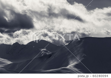 Off piste slope in sunlight clouds at evening 60280094