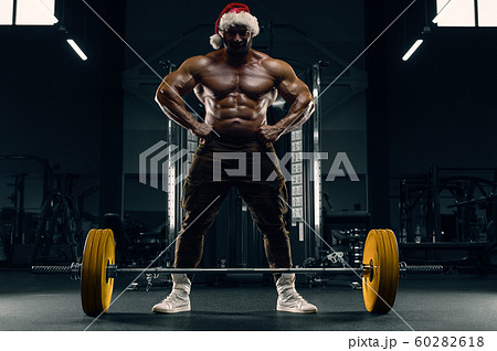 Bodybuilder in Santa Claus costume in the gym Bodybuilder in Santa Claus costume in the gym 60282618