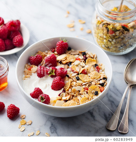 Healthy breakfast. Fresh granola, muesli with yogurt and berries. Marble background. Close up. 60283949