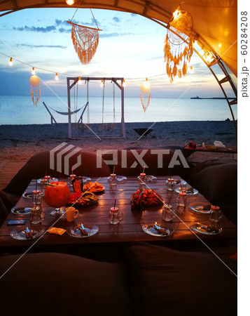 Views of the sea and the laid table with view of the sea during sunset Views of the sea and the laid table with view of the sea during sunset 60284208