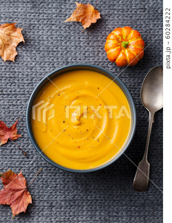Pumpkin, carrot cream soup. Grey textile background. Top view. Pumpkin, carrot cream soup. Grey textile background. Top view. 60284222