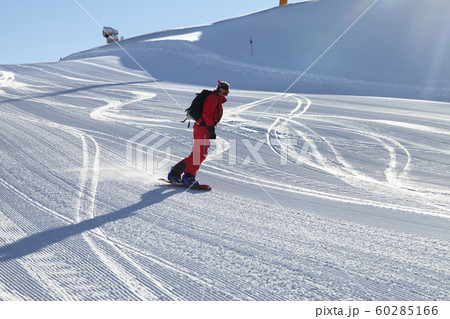 Snowboarder in red downhill on snowy ski slope Snowboarder in red downhill on snowy ski slope 60285166
