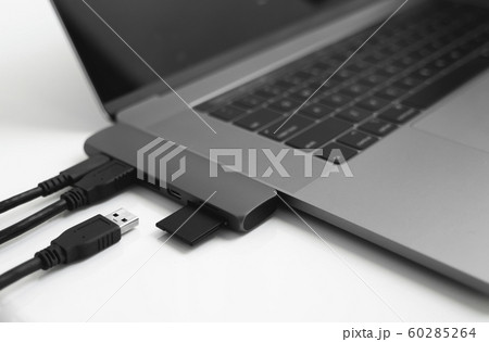 Laptop with USB Type-C adapter with pluged USB cables and SD card. The USB adapter under the Type-C connector for laptop. Multiport station for laptop with multiple different ports. Hub Converter. Laptop with USB Type-C adapter with pluged USB cables and SD card. The USB adapter under the Type-C connector for laptop. Multiport station for laptop with multiple different ports. Hub Converter. 60285264