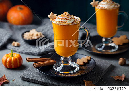 Pumpkin latte with spices. Boozy cocktail with whipped cream on slate board. Grey background. Close up. Pumpkin latte with spices. Boozy cocktail with whipped cream on slate board. Grey background. Close up. 60286590