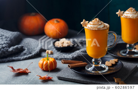 Pumpkin latte with spices. Boozy cocktail with whipped cream on slate board. Grey background. Copy space. Pumpkin latte with spices. Boozy cocktail with whipped cream on slate board. Grey background. Copy space. 60286597