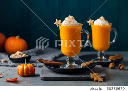 Pumpkin latte with spices. Boozy cocktail with whipped cream on slate board. Grey background. Copy space. 60286620