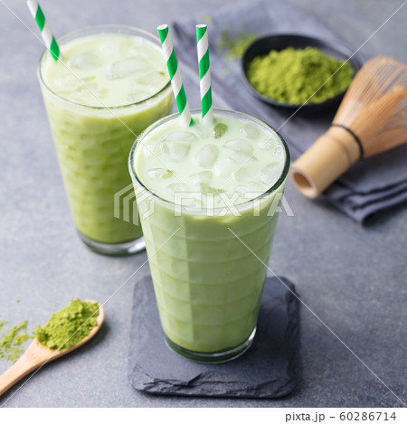 Matcha green tea ice latte with matcha powder and bamboo whisk. Grey background. Close up. 60286714