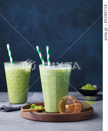 Matcha green tea ice latte with matcha powder and bamboo whisk. Grey background. Copy space. 60286718