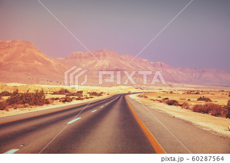 Driving a car in the desert in the early morning Driving a car in the desert in the early morning 60287564