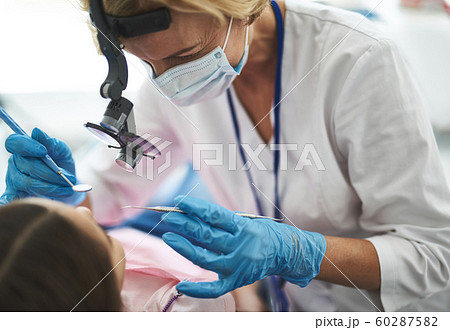 Practitioner is doing dental procedure for girl Practitioner is doing dental procedure for girl 60287582