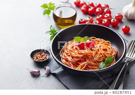 Pasta, spaghetti with tomato sauce in black bowl on grey background. Copy space. 60287951