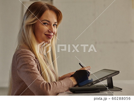 girl artist draws a digital pen on a professional tablet in her studio 60288056
