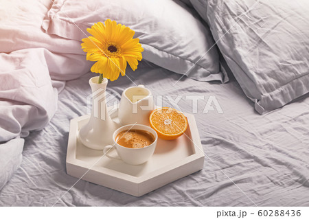 Tray with coffee, milk, orange and yellow flower in a vase. 60288436