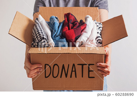 Woman holding a box with clothing close-up. Woman holding a box with clothing close-up. 60288690