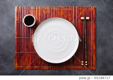 Asian table place setting with white plate, sauce bowl and chopsticks. Top view. Copy space. 60288717