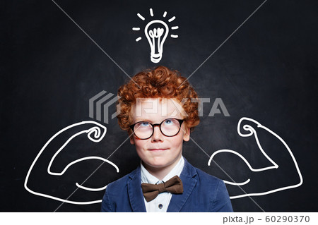 Cute boy with lightbulb on blackboard background. 60290370