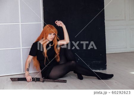 beautiful woman anime cosplayer with red hair with Japanese sword beautiful woman anime cosplayer with red hair with Japanese sword 60292623