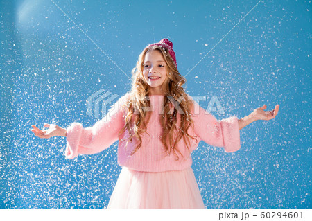 Beautiful fashionable girl in winter snow cap blue background 60294601