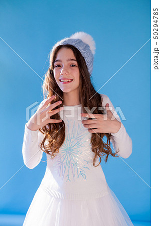 Beautiful fashionable girl in winter snow cap blue background Beautiful fashionable girl in winter snow cap blue background 60294785