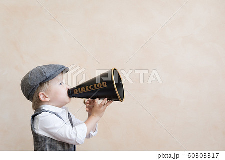 Child shouting through vintage megaphone 60303317