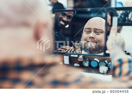 Handsome man looking at mirror in barber shop 60304456