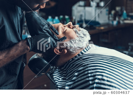 Focused master using blade to shaving client Focused master using blade to shaving client 60304637