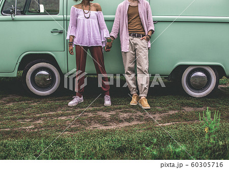 Ethnicity couple holding hands near retro van Ethnicity couple holding hands near retro van 60305716