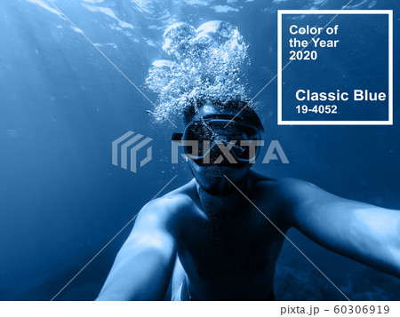 Classic Blue pantone color of the Year 2020. male diver swims in the sea under water with a mask and snorkel 60306919