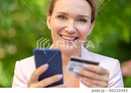 Businesswoman with a credit card and phone makes Businesswoman with a credit card and phone makes 60310483