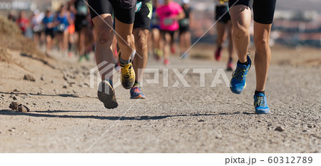 Runners running shoes on trail run. Ultra running athletes legs close up on running in rock path trail 60312789
