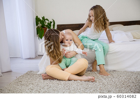 three sisters on the bed in the bedroom in the morning three sisters on the bed in the bedroom in the morning 60314082