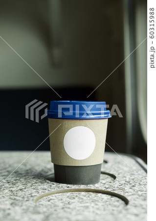 A paper coffee cup with a blue plastic lid and a white inscription circle 60315988