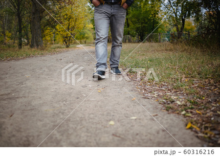 Male legs in jeans and sneakers walking out into 60316216