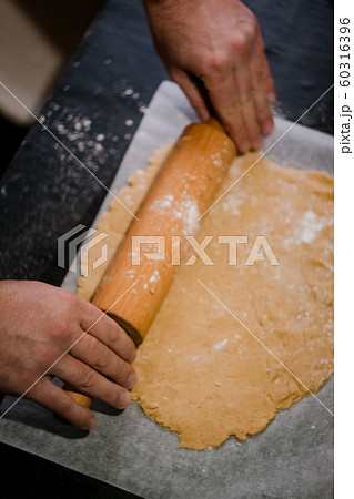 baker's hands roll ginger dough on a dark baker's hands roll ginger dough on a dark 60316396