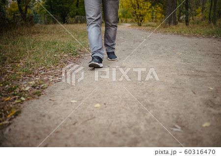 Male legs in jeans and sneakers walking out into 60316470