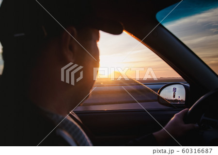 man driving a car at sunset-dawn, close-up, blur. 60316687