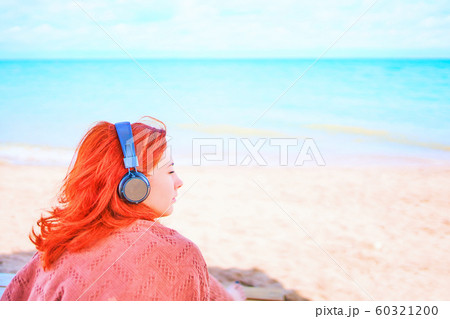 Beautiful woman listening to music on the beach. Beautiful woman listening to music on the beach. 60321200