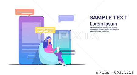 woman using laptop computer chatting app social network speech chat bubble communication concept girl sitting on bean bag smartphone screen full length copy space horizontal 60321513
