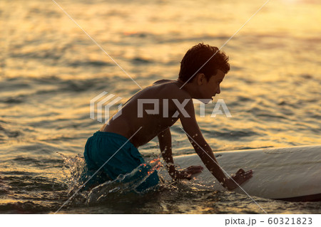 a tired guy with a surf rack in a bathing suit to learn slides on the waves 60321823
