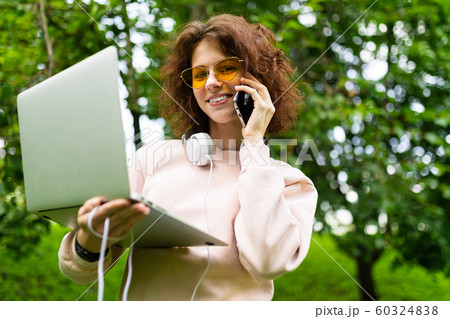 Pretty young caucasian woman is engaged in freelance in the park and call the phone Pretty young caucasian woman is engaged in freelance in the park and call the phone 60324838