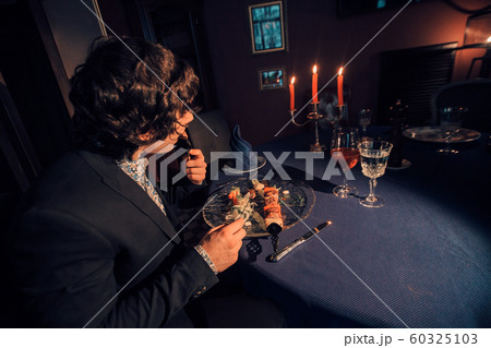 businessman dining in a restaurant by candlelight. Man eating barbecue. Concept of meat dishes, Caucasian cuisine, business lunch, romantic dinner businessman dining in a restaurant by candlelight. Man eating barbecue. Concept of meat dishes, Caucasian cuisine, business lunch, romantic dinner 60325103