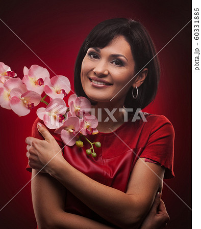 Brunette woman with shiny hair . Beautiful model on red background. 60331886