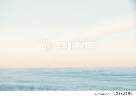 flying above the clouds at sunset landscape from an airplane 60332196