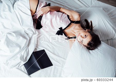 girl in pajamas lying on the bed with a book before bed girl in pajamas lying on the bed with a book before bed 60333244