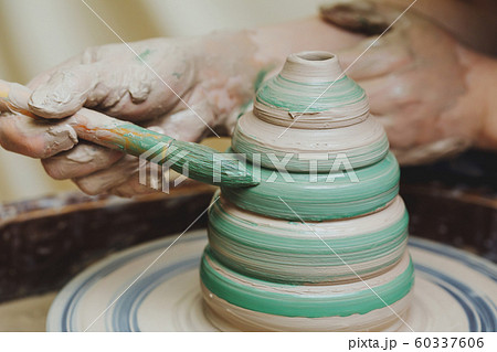Hands on pottery wheel. Craftsman artist painting Hands on pottery wheel. Craftsman artist painting 60337606