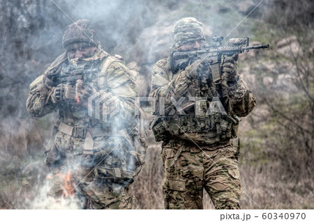 military soldiers attacking enemies trough smoke screen 60340970